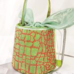 Priscilla, le sac à main bicolore vert et rouge, ajoutant une touche de glamour à chaque tenue.