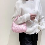 Femme arborant un sac à main rose Randy sur son bras.