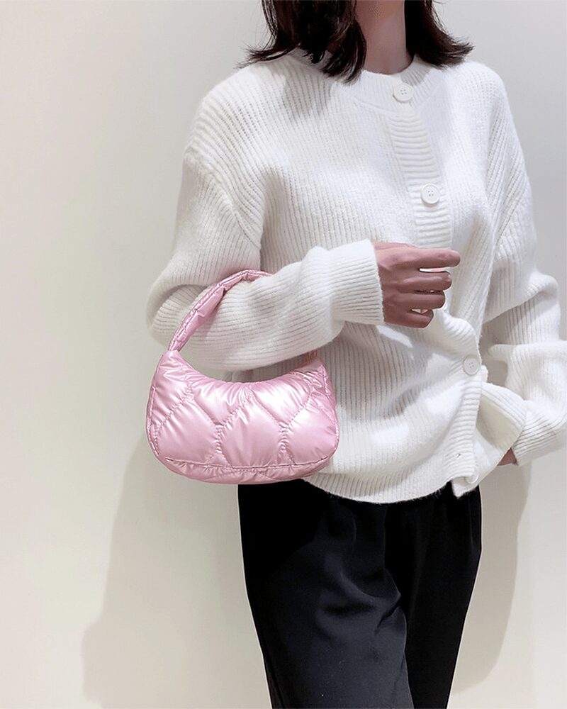 Femme arborant un sac à main rose Randy sur son bras.