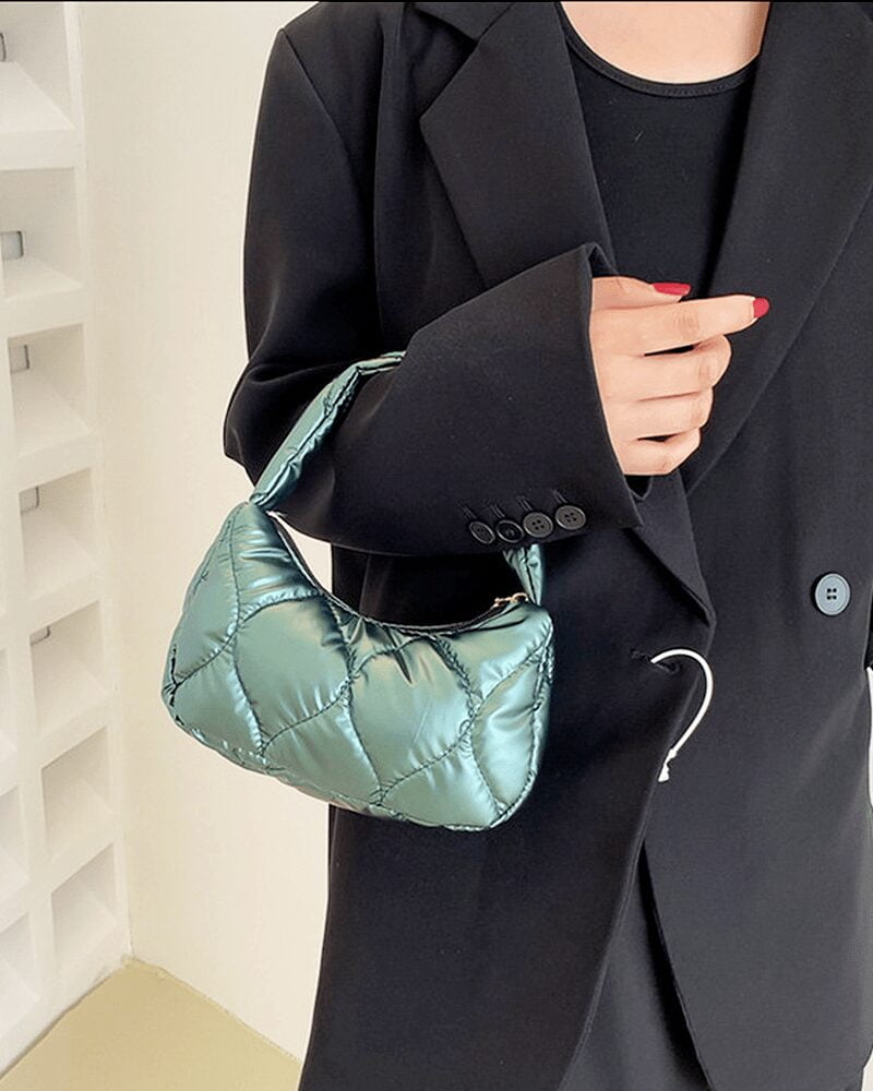 Femme portant un sac à main vert Randy sur son bras.
