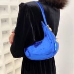Sac à main Sara bleu vernis motif crocodile femme porté à l'épaule.