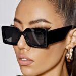 Femme élégante arborant les lunettes de soleil 'Alice' noir vintage pour une protection UV400 et un look vintage.