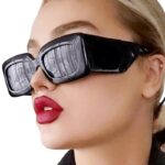 "Femme portant les lunettes de soleil 'Alice' noir vintage pour une protection UV400 et un look rétro.