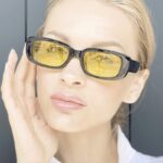 Femme portant les lunettes de soleil tendance Becky noir et jaune avec protection UV400.