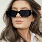 Femme portant les lunettes de soleil tendance Becky noires avec protection UV400.