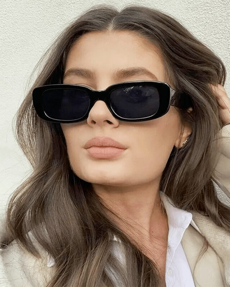 Femme portant les lunettes de soleil tendance Becky noires avec protection UV400.