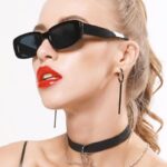 Femme portant les lunettes de soleil tendance Becky noires avec protection UV400.