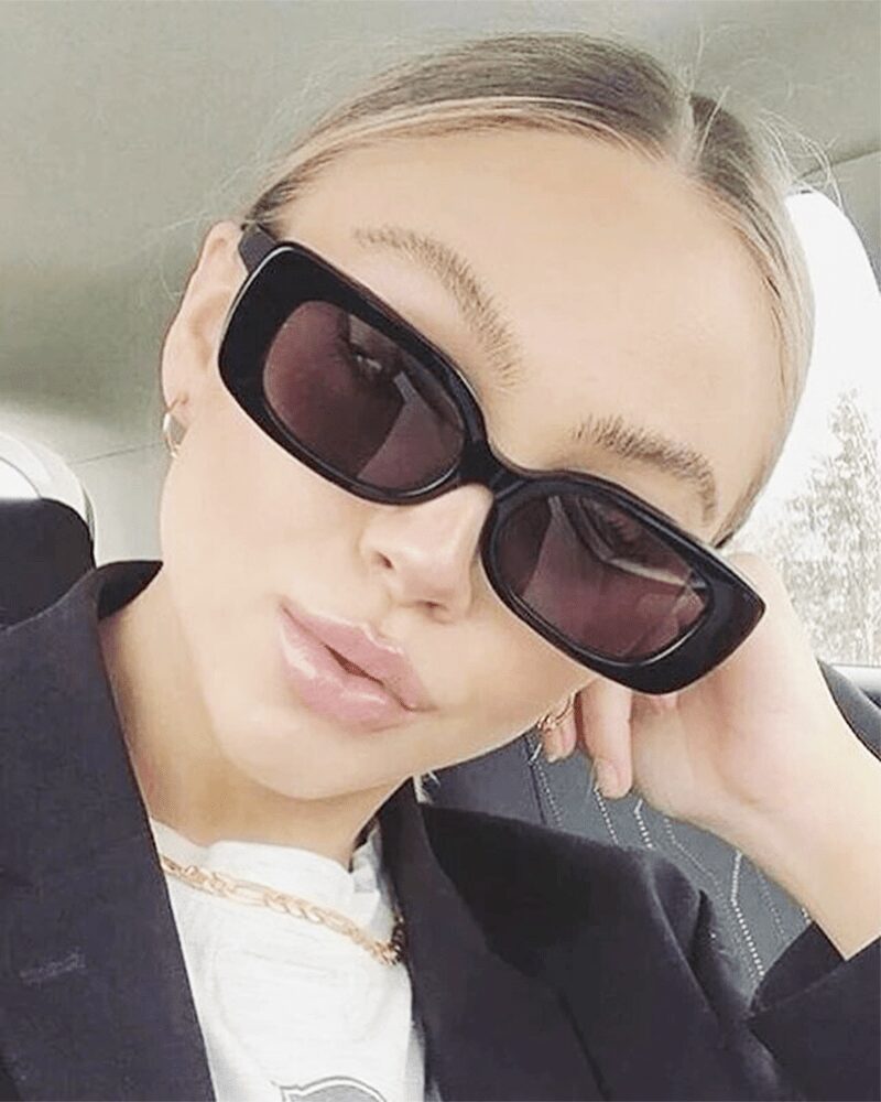 Femme portant les lunettes de soleil tendance Becky noires avec protection UV400.