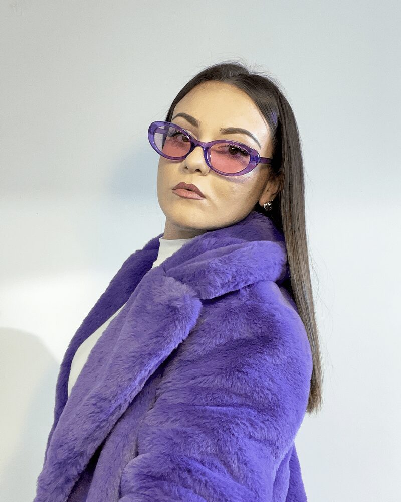 Lunettes de soleil violet tendance Betsy avec protection UV400, portées par une femme.