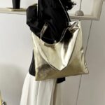 Sac à main fourre-tout Elsa couleur champagne brillant - accessoire chic porté à l'épaule pour femme.