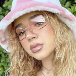 Un charme vintage sous le soleil moderne. Découvrez nos lunettes de soleil Gracie rétro avec protection UV400, magnifiées par une femme au style classique, disponibles chez Izamel.