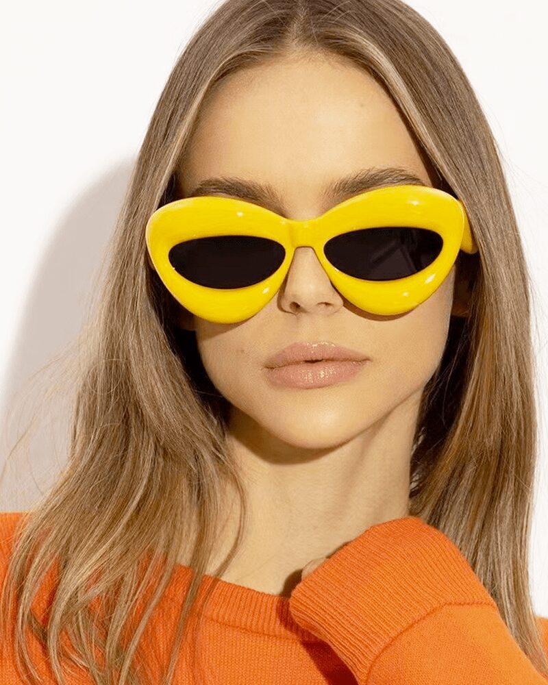 Lunettes de soleil originales Kelly jaunes, offrant une protection UV400, portées par une femme.