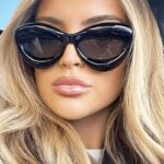 Lunettes de soleil originales Kelly noires, offrant une protection UV400, portées par une femme.