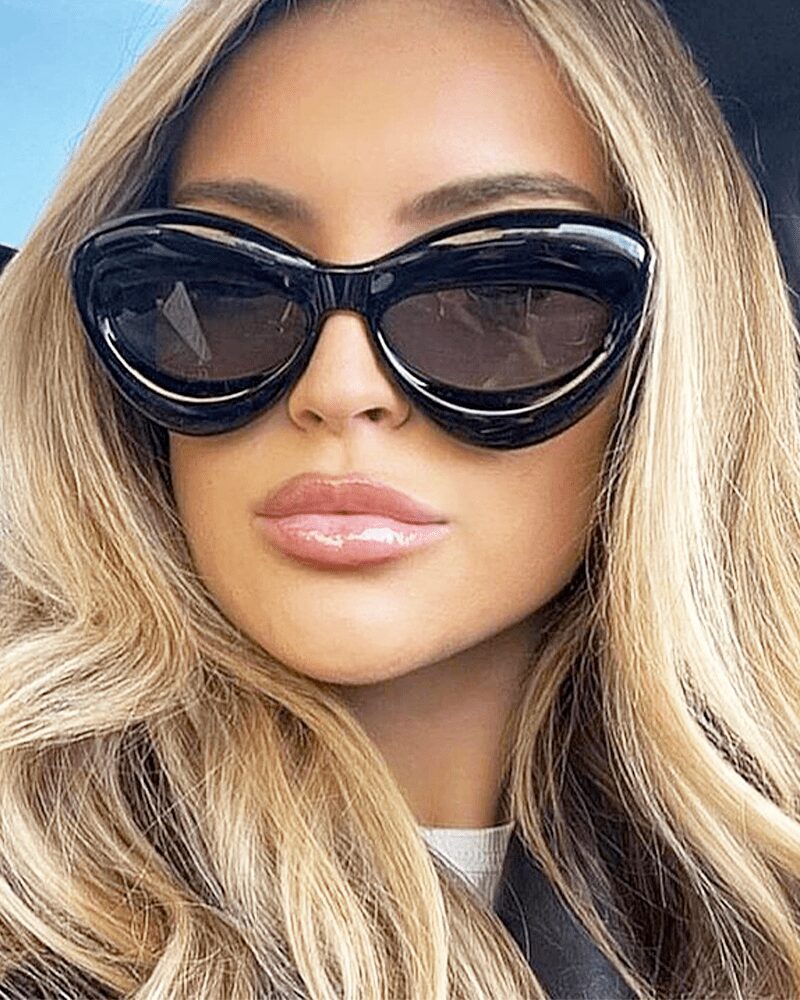 Lunettes de soleil originales Kelly noires, offrant une protection UV400, portées par une femme.