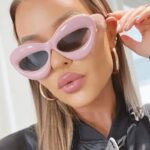 Femme portant la paire de lunettes Kelly roses pour une protection UV400, disponible chez Izamel.