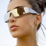 Lunettes de soleil argentées Kyle, accessoire de style streetwear avec protection UV400, joliment portées par une femme.