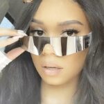 Lunettes de soleil argentées Kyle, accessoire de style streetwear avec protection UV400, portées avec charme par une femme.