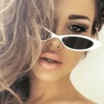 Lunettes de soleil Livia blanc rétro avec protection UV400, portées par une femme.