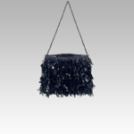 Sac à bandoulière noir pailleté Mandy, un accessoire de mode sophistiqué déniché à la boutique Izamel, porté avec style par une femme.