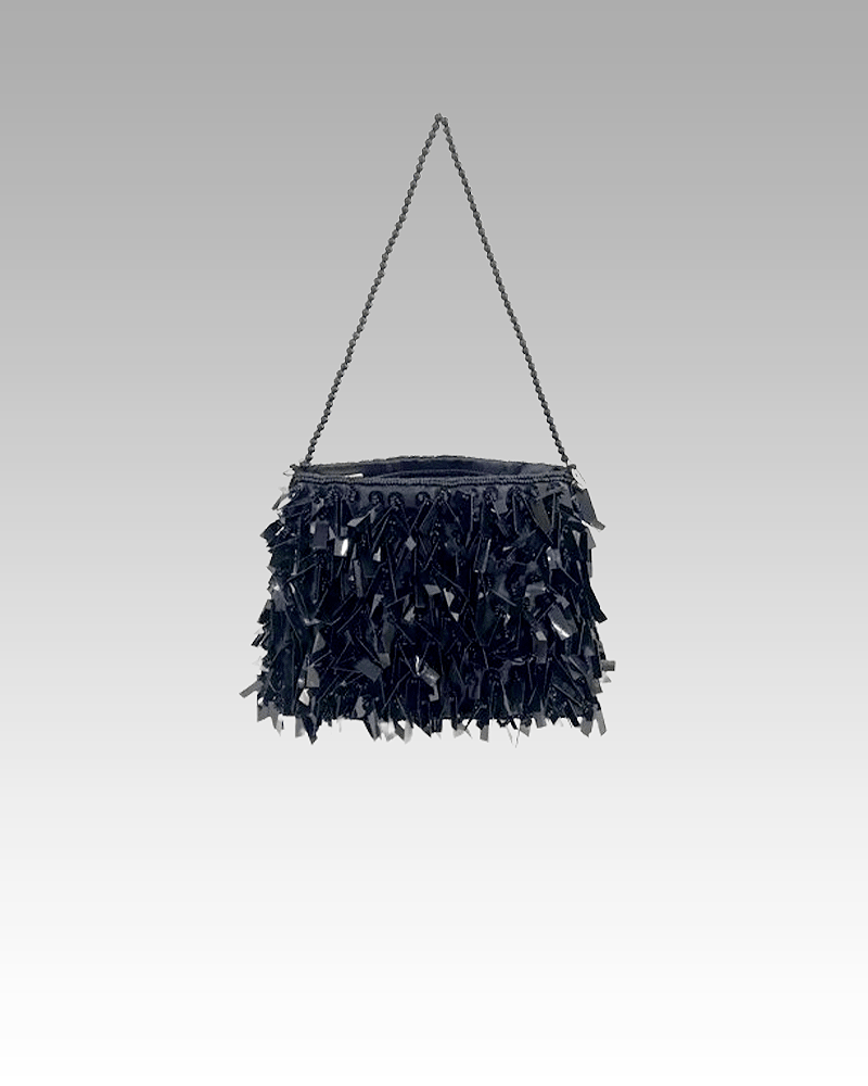 Sac à bandoulière noir pailleté Mandy, un accessoire de mode sophistiqué déniché à la boutique Izamel, porté avec style par une femme.