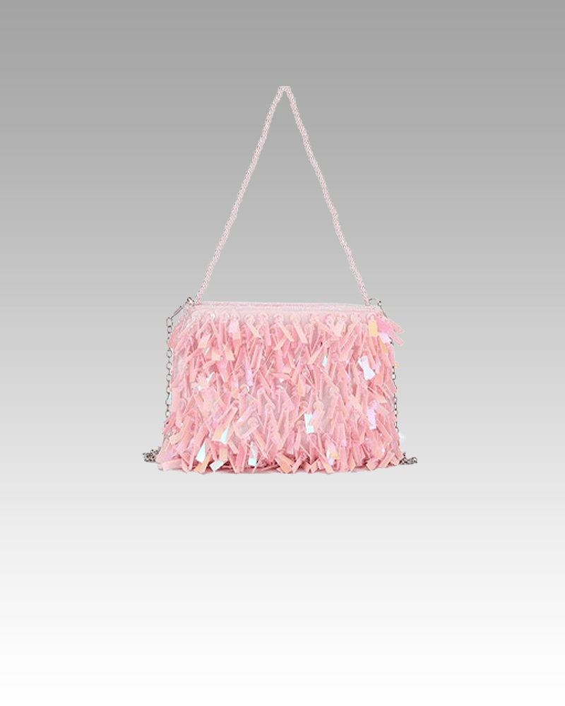 Sac à bandoulière rose pailleté Mandy, accessoire de mode charmant provenant de la boutique Izamel, porté avec grâce par une femme.