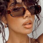 Femme portant les lunettes de soleil 'Noémie' motif léopard, pour une protection UV400 et un look tendance.