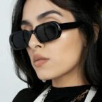 Femme portant les lunettes de soleil 'Noémie' noir branché pour une protection UV400 et un look tendance.