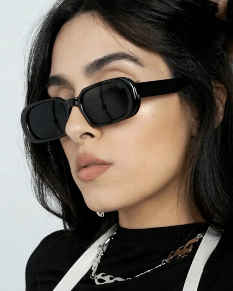 Femme portant les lunettes de soleil 'Noémie' noir branché pour une protection UV400 et un look tendance.