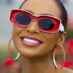 Lunettes de soleil Pretty rouge rétro avec protection UV400 portées par une femme.