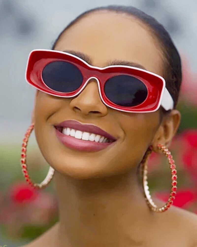 Lunettes de soleil Pretty rouge rétro avec protection UV400 portées par une femme.