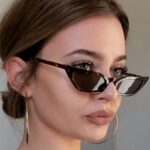 Lunettes de soleil Valentina motif léopard au style rétro, offrant une protection UV400, portées par une femme.