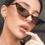 Lunettes de soleil Valentina motif léopard au style rétro, offrant une protection UV400, portées par une femme.