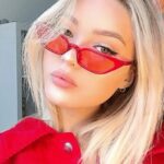 Illuminez votre style avec les lunettes de soleil Valentina rouges : Style rétro, avec protection UV400, portées avec élégance par une femme.