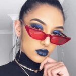 Lunettes de soleil Valentina rouges au style rétro, offrant une protection UV400, portées par une femme.