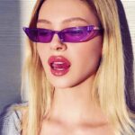 Lunettes de soleil Valentina violettes au style rétro, offrant une protection UV400, portées par une femme.
