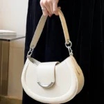 Sac à main Anaïs en similicuir blanc tenu à la main par une femme, disponible chez Boutique Izamel.