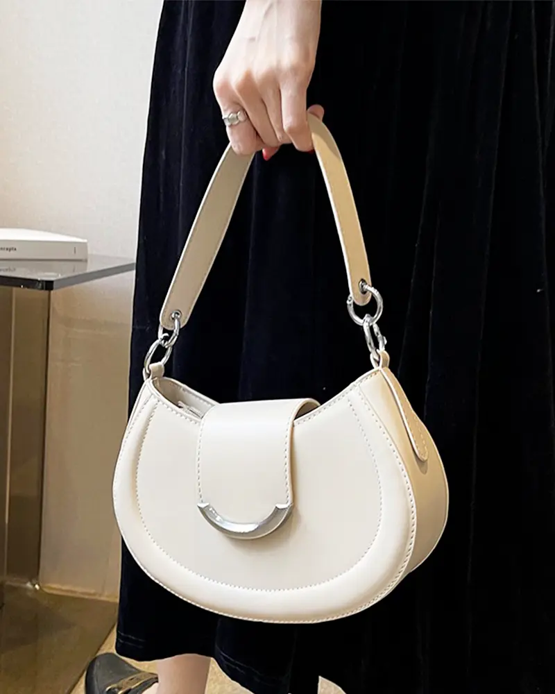 Sac à main Anaïs en similicuir blanc tenu à la main par une femme, disponible chez Boutique Izamel.