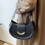 Sac à main Anaïs en similicuir noir porté au bras par une femme, disponible chez Boutique Izamel.