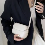 Sac à main Emy en similicuir blanc avec bandoulière, porté par une femme, disponible chez Boutique Izamel.