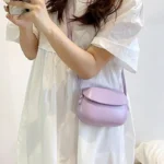 Sac à main Emy en similicuir lila avec bandoulière porté par une femme, disponible chez Boutique Izamel.