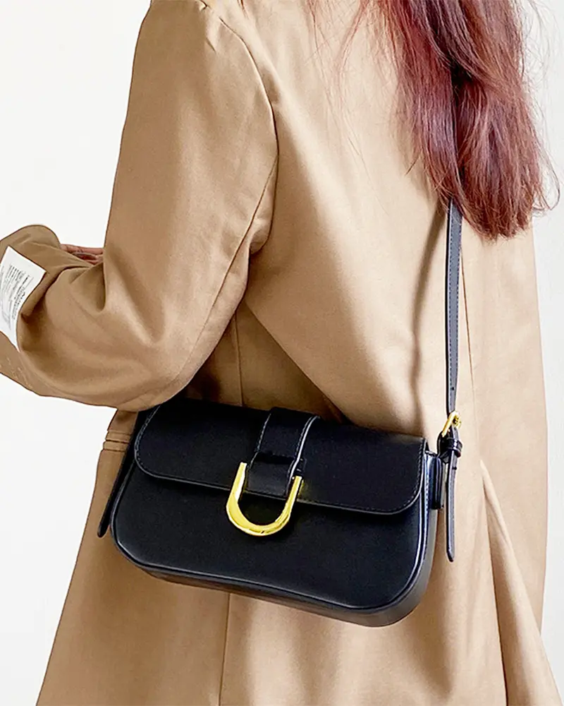 Sac à bandoulière noir vernis Inaya porté par une femme