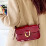 Sac à bandoulière rouge vernis Inaya porté par une femme