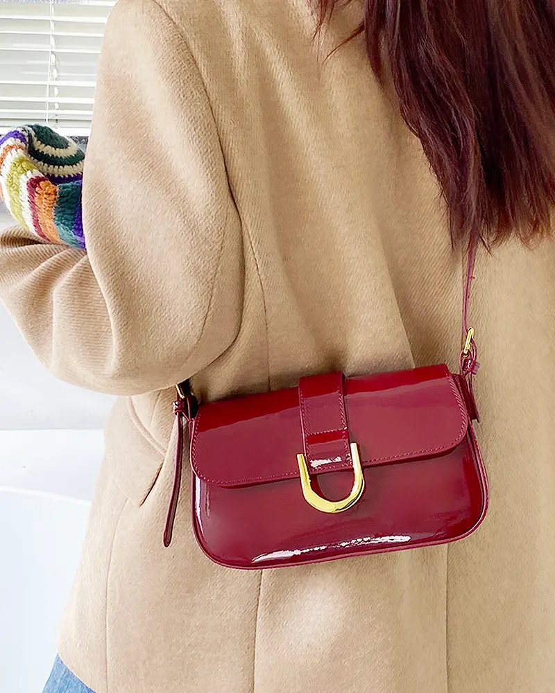 Sac à bandoulière rouge vernis Inaya porté par une femme