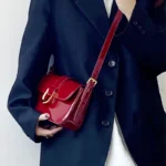 Sac à bandoulière rouge vernis Inaya porté par une femme