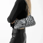 Sac à main Iris avec motif léopard blanc porté à l'épaule par une femme, disponible chez Boutique Izamel.