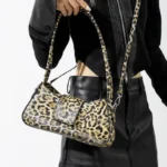 Sac à main Iris avec motif léopard porté en bandoulière par une femme, disponible chez Boutique Izamel.