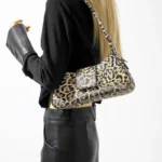 Sac à main Iris avec motif léopard porté à l'épaule par une femme, disponible chez Boutique Izamel.