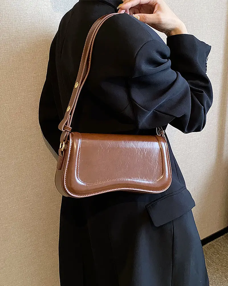 Sac à main Lina en similicuir marron porté à l'épaule par une femme, disponible chez Boutique Izamel.