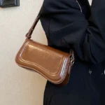 Sac à main Lina en similicuir marron porté à l'épaule par une femme – Boutique Izamel.
