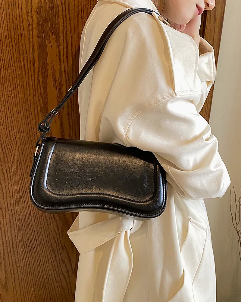 Sac à main Lina en similicuir noir porté à l'épaule par une femme, disponible chez Boutique Izamel.